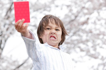Photo for Angry little Japanese boy holding red card - Royalty Free Image