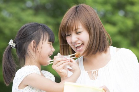Photo for Mother and daughter eating in park - Royalty Free Image