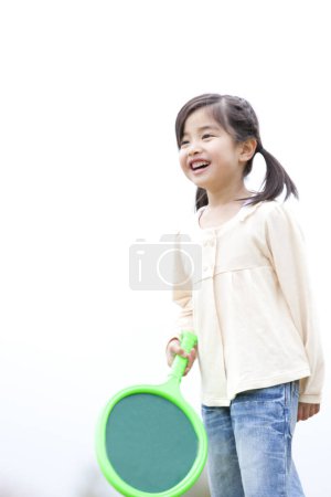 Téléchargez les photos : Portrait de asiatique fille avec vert raquette jouer dans parc - en image libre de droit