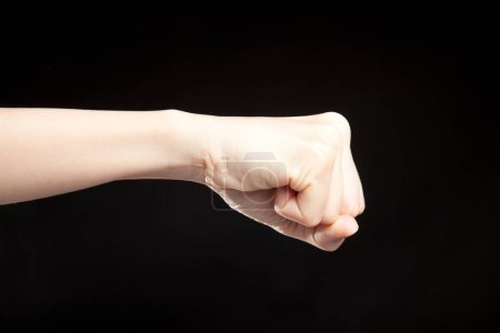 Foto de Primer plano de la mano de la mujer mostrando gesto sobre fondo negro - Imagen libre de derechos