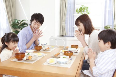 Photo for Happy asian family praying before lunch - Royalty Free Image