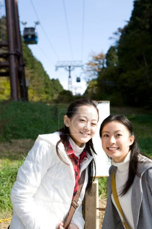 Téléchargez les photos : Deux asiatique les femmes debout sous câble manière - en image libre de droit