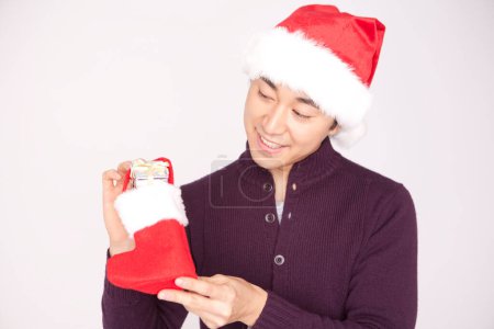 Téléchargez les photos : Fermer asiatique homme holding stocking avec cadeau - en image libre de droit