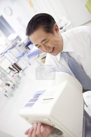 asian male doctor checking blood preasure