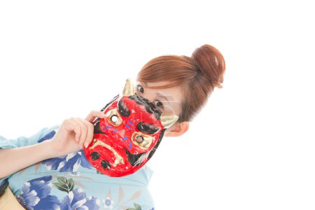 Téléchargez les photos : Femme en kimono traditionnel japonais tenant un masque rouge avec des cornes - en image libre de droit