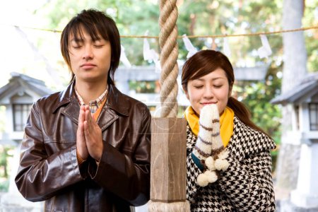 Foto de Joven asiático pareja orando en templo - Imagen libre de derechos