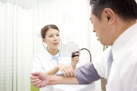Arzt überprüft Blutwerte von Patienten in Arztpraxis