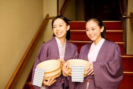 japanese women wearing traditional kimonos with baskets