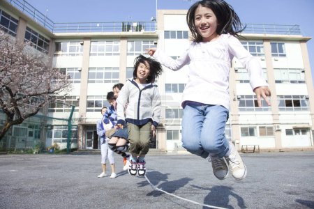 Téléchargez les photos : Groupe d'enfants jouant sur la cour de l'école, concept de l'école - en image libre de droit