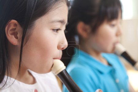 Téléchargez les photos : Petite asiatique fille jouer flûte - en image libre de droit
