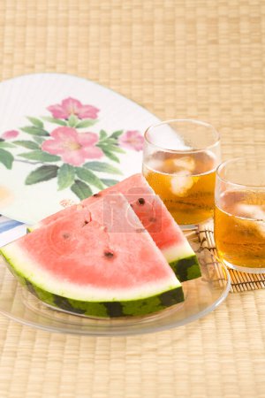 Téléchargez les photos : Vue rapprochée des tranches de pastèque et du thé froid sur la table. collations et boissons d'été - en image libre de droit