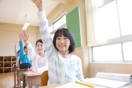 Photo for Japanese children sitting at classroom during lesson - Royalty Free Image