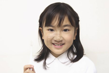 Foto de Asiático niña con un cepillo de dientes cepillarse los dientes - Imagen libre de derechos