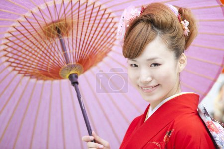 Foto de Hermosa joven japonesa en traje tradicional en el templo con paraguas de papel antiguo - Imagen libre de derechos