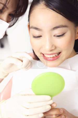 Téléchargez les photos : Jeune asiatique femme obtention son dents traitement à dentiste bureau - en image libre de droit