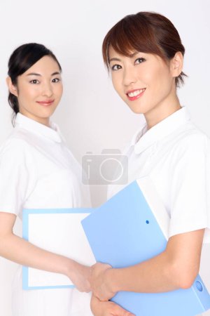 Téléchargez les photos : Portrait de deux infirmières japonaises en uniforme blanc - en image libre de droit