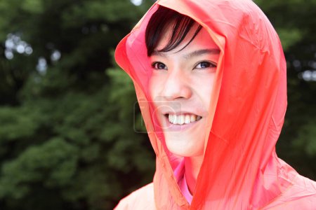 Foto de Un hombre con un impermeable rojo sonriendo - Imagen libre de derechos
