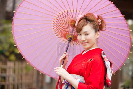Foto de Hermosa japonesa joven mujer usando tradicional kimono celebración paraguas - Imagen libre de derechos