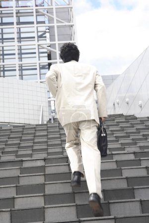 Téléchargez les photos : Un homme en costume montant les escaliers - en image libre de droit