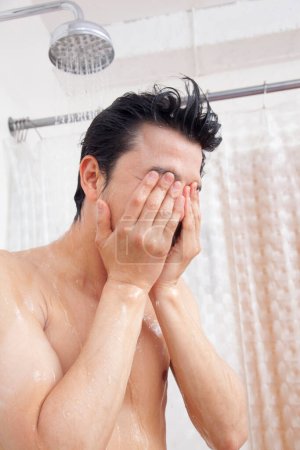 Photo for Asian man taking shower in bathroom - Royalty Free Image