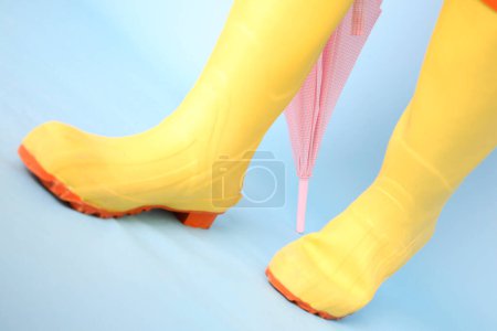 Foto de Botas de goma amarillas sobre fondo azul - Imagen libre de derechos