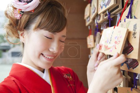 Téléchargez les photos : Belle japonais femme dans kimono holding ema dans sanctuaire. - en image libre de droit