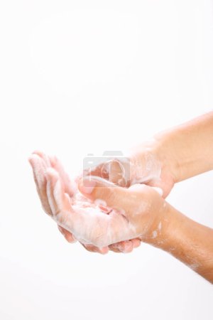 Téléchargez les photos : Homme se laver les mains avec du savon sur fond blanc - en image libre de droit