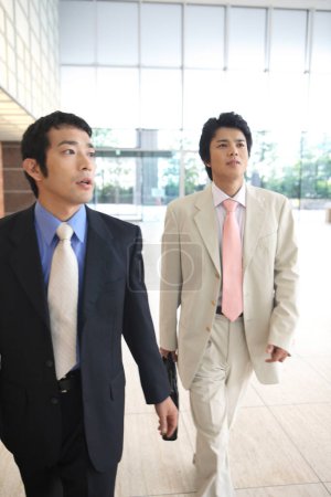 Téléchargez les photos : Gens d'affaires marchant dans le bureau - en image libre de droit