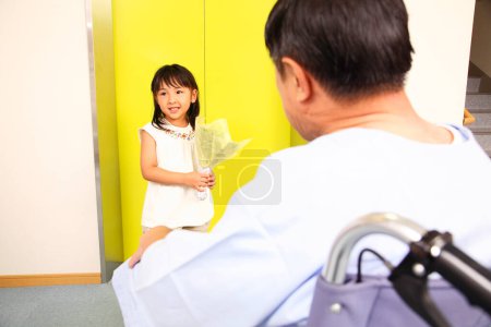 Photo for Cute little asian girl visiting her grandfather at hospital with flowers - Royalty Free Image