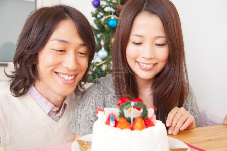 Téléchargez les photos : Jeune asiatique couple célébrant noël avec gâteau - en image libre de droit