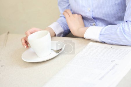 Photo for A person sitting at a table with a cup of coffee - Royalty Free Image