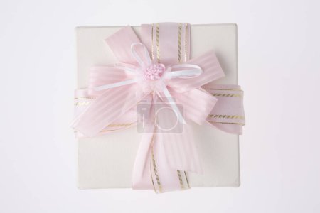 Téléchargez les photos : Boîte cadeau blanche avec ruban rose sur fond blanc - en image libre de droit