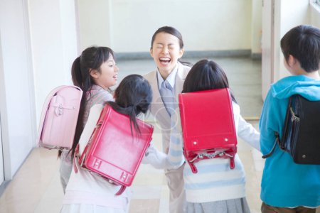 Foto de Escolares felices con el profesor en el pasillo escolar - Imagen libre de derechos