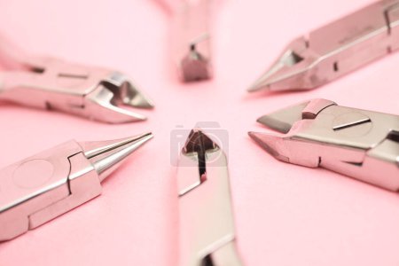 Téléchargez les photos : Vue rapprochée des instruments dentaires en métal sur fond rose - en image libre de droit
