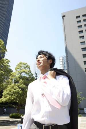 Téléchargez les photos : Un homme en chemise blanche et cravate noire dans la rue - en image libre de droit