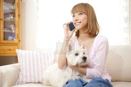 Photo for Happy woman with dog talking on smartphone - Royalty Free Image