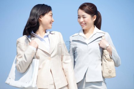 Photo for Two women in business attire walking together - Royalty Free Image