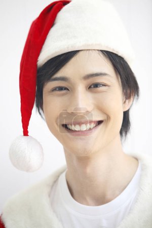 Photo for Handsome Japanese man dressed as Santa Claus - Royalty Free Image