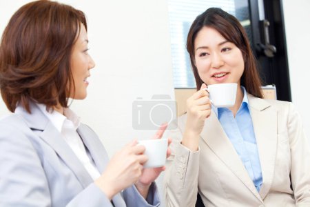 Téléchargez les photos : Deux femmes ayant une conversation tout en buvant du café - en image libre de droit