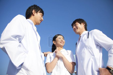Photo for Three young asian doctors standing ourdoors - Royalty Free Image