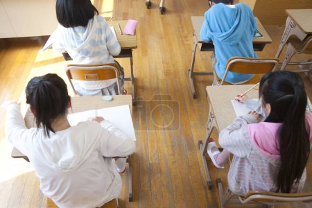 Photo for Japanese children sitting at desks in classroom - Royalty Free Image