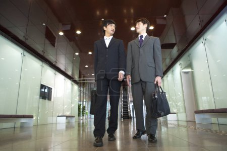 Foto de Dos hombres en trajes de pie en un pasillo - Imagen libre de derechos