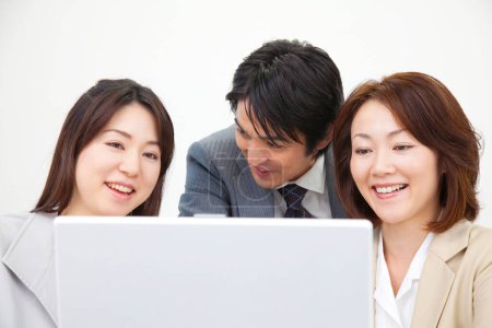 Photo for Japanese businesspeople working with laptop in office together - Royalty Free Image