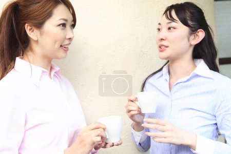 Téléchargez les photos : Deux jeunes employées de bureau avec des tasses de café - en image libre de droit