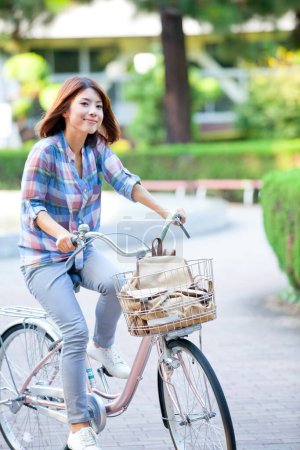 Foto de Feliz mujer japonesa montar bicicleta - Imagen libre de derechos