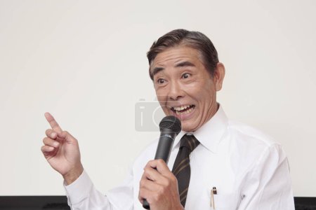 Photo for Mature japanese speaker with microphone standing near white board - Royalty Free Image