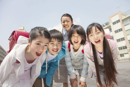 Foto de Grupo de escolares japoneses con el profesor posando en el patio de la escuela - Imagen libre de derechos