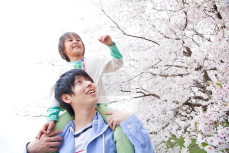 Photo for Happy japanese father and son enjoying spring time in the park - Royalty Free Image