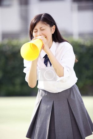 Téléchargez les photos : Belle écolière japonaise en uniforme avec haut-parleur - en image libre de droit