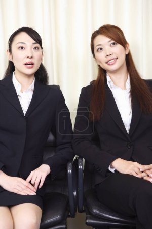 Photo for Two women in business attire sitting on chairs - Royalty Free Image